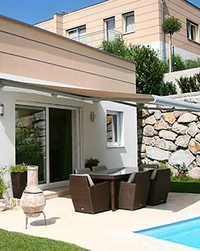 Markisen – Haus mit Markise, Terrasse und Pool im Garten
